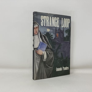 May include: A book titled "Strange Loop" by Amanda Prantera. The cover shows a nun holding a blue book, with a church and moon in the background. The book is set against a white backdrop.