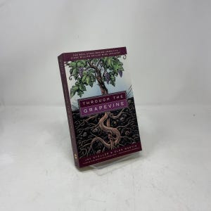 May include: A hardcover book titled "Through the Grapevine" with a cover illustration of a grapevine and roots. The book's title is in a rectangular box with a purple background. The book's subtitle is "The Real Story Behind America's Eight Billion Dollar Wine Industry."