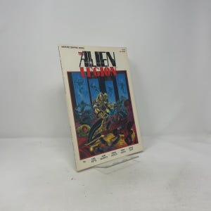 May include: A comic book titled "The Alien Legion" by Marvel Graphic Novel. The cover features a futuristic illustration of armored figures in a battle scene with a red and blue color scheme. The book is propped up on a clear stand.