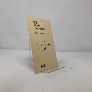 May include: A beige booklet titled "E-Z Cusp Corrector" by John A. Hanson. The cover features a black and white illustration of a circle with an arrow pointing to the right.