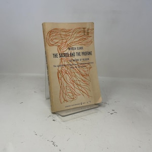 May include: A paperback book titled The Sacred and the Profane: The Nature of Religion by Mircea Eliade. The cover is beige with orange and green abstract line art, black text, and the Harper Torchbooks logo at the bottom center.
