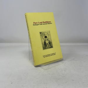 May include: A yellow book titled "Pure Land Buddhism: Dialogues with Ancient Masters." The book features an illustration of a figure and text on the cover. The Sutra Translation Committee of the United States and Canada is also printed on the cover.