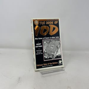 Op de afbeelding: Een paperback boek getiteld "THE BOOK OF YOD" met de ondertitel "The Eater of Souls & other tales". De cover heeft gouden letters en een gedetailleerde illustratie van een kist. De auteur is Henry Kuttner. Het boek maakt deel uit van de serie "Thirteen Tales of the Mythos".