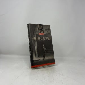 May include: A hardback book titled Threads of Time by Peter Brook. The black and white cover features a photograph of a person walking through a dark architectural space. The title and author name are printed in white and red text on the front.