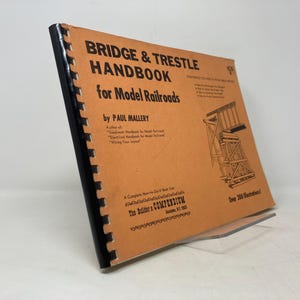 May include: A brown and black book titled "Bridge & Trestle Handbook for Model Railroads" by Paul Mallery. The book cover features a black and white illustration of a bridge.