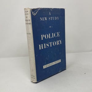 Pode incluir: Um livro azul com o título "A New Study of Police History" de Charles Reith.