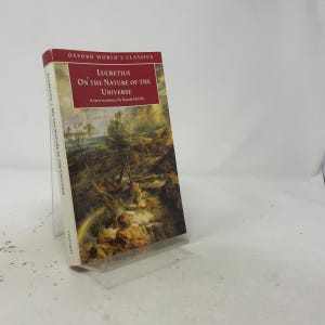 May include: A paperback book titled On the Nature of the Universe by Lucretius, part of the Oxford World's Classics series. The cover features a dark, atmospheric landscape painting with trees and rocks, and the text is printed in white and red.
