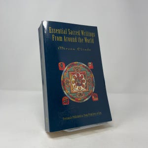 May include: A hardcover book titled "Essential Sacred Writings From Around the World" by Mircea Eliade. The book has a dark blue cover with gold lettering and a colorful circular design. The text "Previously Published as From Primitives to Zen" is at the bottom.