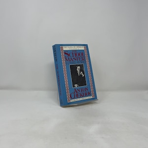 May include: A hardcover book titled "The School Master & Other Stories" by Anton Chekhov. The book has a blue cover with gold lettering and a portrait of a man. The book is part of "The Tales of Chekhov" series.