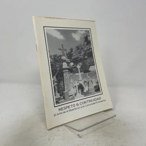May include: A softcover book with a cream-coloured cover featuring a black and white photograph of a cemetery with crosses and hillside structures. The title text reads RESPETO & CONTINUIDAD and the subtitle reads El Arte de la Muerte en una Comunidad Fronteriza.