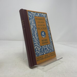 May include: A vintage copy of McGuffey's Fourth Eclectic Reader, Revised Edition. The book has a maroon spine and a cover with blue and white floral designs. The title is in gold lettering, with the publisher's name at the bottom.