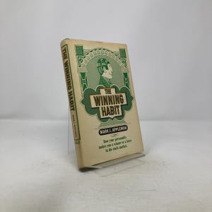 May include: A vintage book titled "The Winning Habit" by Mark J. Appleman. The book has a cream-colored cover with green and brown text and illustrations. The cover features a man's profile and the text "Sell High, Profit".