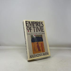 Puede incluir: Un libro de tapa dura titulado "Empires of Time" de Anthony Aveni. La portada es de color crema con el título en letras negras grandes y un gráfico de un reloj de sol. El subtítulo dice "Calendarios, Relojes y Culturas."