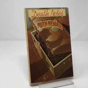 May include: A hardcover book titled Death Notes by Ruth Rendell. The cover features an illustration of an open brown trunk on a brick floor, with a person's arm visible inside. The title and author name are printed in red and gold lettering.