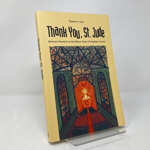 May include: A yellow book with the title "Thank You, St. Jude" and the subtitle "Women's Devotion to the Patron Saint of Hopeless Causes". The cover features a stained glass window with a red, yellow, and green design.