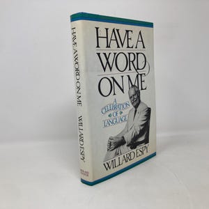 May include: A book titled "Have a Word on Me: A Celebration of Language" by Willard Espy. The cover features a black and white photo of a man in a suit and tie.