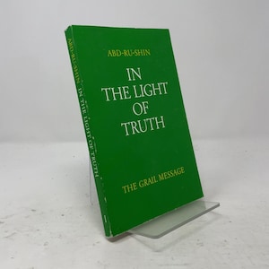 May include: A green hardcover book titled In the Light of Truth by Abd-Ru-Shin, with the subtitle The Grail Message printed in yellow text on the front cover. The title is displayed in white capital letters, and the spine shows the same text.