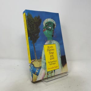 May include: A hardcover book titled Actors, Pilgrims, Kings and Gods: The Ramlila at Ramnagar by Anuradha Kapur. The cover features a green-faced figure against a blue sky, a tall tree, and a yellow rectangular box with the book title text.