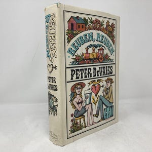 May include: A vintage hardcover book titled "Reuben, Reuben" by Peter DeVries. The cover features colorful illustrations of a train, a house, and figures. The spine displays the title and author.