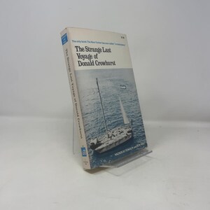May include: A paperback book titled "The Strange Last Voyage of Donald Crowhurst" with a blue and white cover featuring a sailboat on the ocean. The book's spine and cover text are visible, along with the author's names.