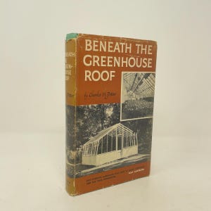 May include: A hardcover book titled Beneath the Greenhouse Roof by Charles H. Potter. The dust jacket features a rust-orange upper section with white text and a lower section with black and white photographs of a greenhouse structure.