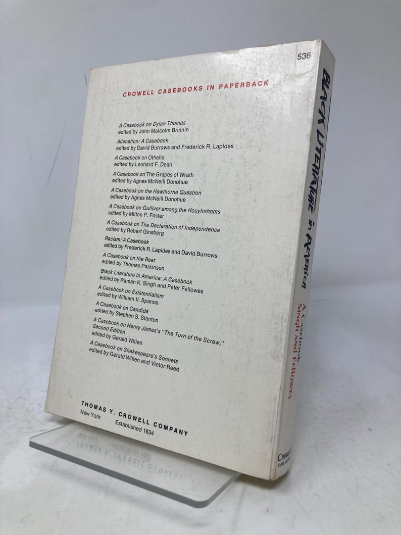Puede incluir: Un libro de bolsillo titulado "Black Literature in America: A Casebook" de Singh y Fellowes. El libro tiene una cubierta blanca con texto negro, incluido el nombre del editor y una lista de casos.