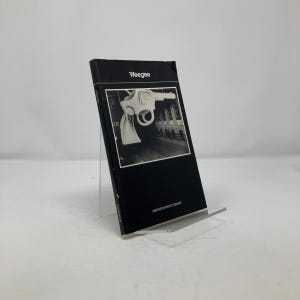 May include: A black and white photo book titled "Weegee" with a photo of a large gun on the cover. The book is part of the Smithsonian Photo Library.