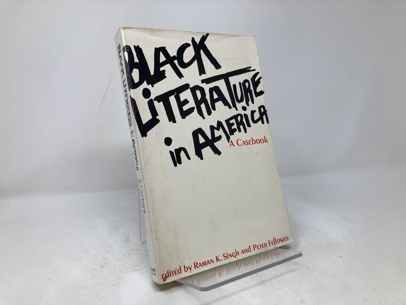 Puede incluir: Un libro de tapa dura de color crema titulado "Black Literature in America: A Casebook". El t&iacute;tulo est&aacute; en letras negras en negrita. Editado por Raman K. Singh y Peter Fellowes.