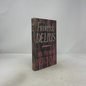 Op de afbeelding: Een hardcover boek met de titel "Frederick Delius" door Sir Thomas Beecham. De omslag heeft een bruine en roze kleurstelling, met de titel in grote, witte letters. Het boek staat rechtop tegen een effen achtergrond.