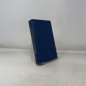 May include: A hardcover book titled "Shakespeare and Jonson" in a dark blue cover. The book is propped up on a clear plastic stand. The title is printed in white on the spine.