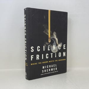 May include: A hardcover book titled "SCIENCE FRICTION" with a black cover. The title is in large white letters, with the subtitle "Where the Known Meets the Unknown." A burning match is depicted on the cover. The author's name is Michael Shermer.