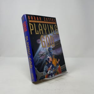 May include: A white ceramic mug with a black handle and the text "But First, Coffee" in a bold, black font. The mug is set against a blurred background, suggesting a cosy setting.