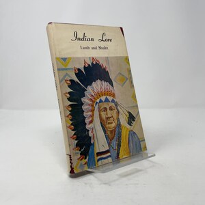 May include: Vintage book titled "Indian Lore" by Lamb and Shultz. The cover features a portrait of a Native American man wearing a feathered headdress. The book has a cream-colored cover with text and illustrations.