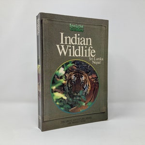 May include: A green book titled "Indian Wildlife" with a photo of a tiger in the jungle on the cover. The book is part of the "Insight Guides" and "The Great Adventure Series" by APA Productions. The book also mentions Sri Lanka and Nepal.