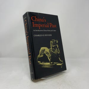Pode incluir: Um livro de capa dura intitulado China's Imperial Past: An Introduction to Chinese History and Culture de Charles O. Hucker. A sobrecapa preta apresenta texto em vermelho e uma ilustração dourada de uma criatura mítica.