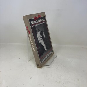 May include: A book titled "Strictly Dishonorable and Other Lost American Plays" is displayed on a clear stand. The cover features a black and white image of two people. The title is in red and white text.