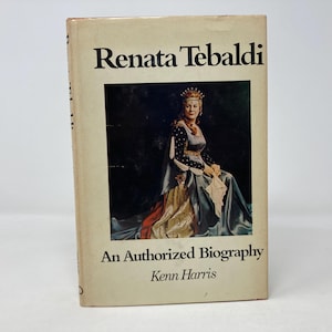 以下が含まれることがあります： レナータ・テバルディの肖像画が表紙の書籍。オペラ歌手である彼女は、王冠と青と金のガウンを着用しています。書籍のタイトルは「レナータ・テバルディ：公認伝記」ケーン・ハリス著です。