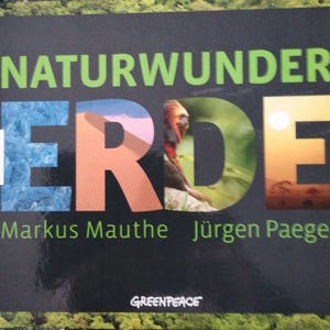 Könnte beinhalten: Ein Buchcover mit dem Titel "Naturwunder Erde" in grüner und weißer Schrift. Der Titel ist umgeben von Bildern eines blauen Gletschers, einer roten Sanddüne, eines grünen Dschungels und eines Sonnenuntergangs. Das Buch ist von Markus Mauthe und Jürgen Paeger und trägt das Greenpeace-Logo.