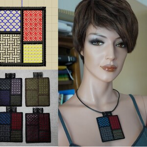 Puede incluir: Cuatro cuadrados de tela bordados con diferentes patrones en azul, rojo, amarillo y negro. Los cuadrados están dispuestos en una cuadrícula. Los cuadrados de tela están unidos a un collar de cordón negro.
