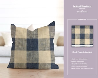 Op de afbeelding: Een blauwe en beige geruite kussenhoes. De kussenhoes is gemaakt van 100% polyester en heeft afgezoomde naden voor duurzaamheid. De kusseninleg is niet inbegrepen. "Check Please in Lakeland" staat op de beschrijvingskaart.