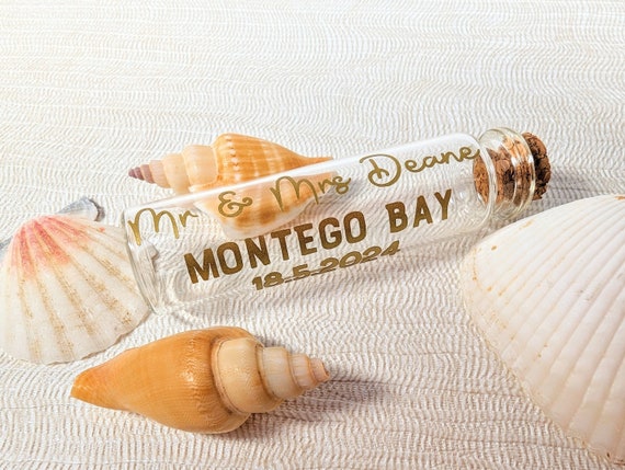 A tiny personalised jar of actual destination-wedding or honeymoon sand — dead simple concept, wildly sentimental, and 137 favorites prove people keep buying it.