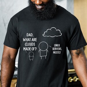May include: Black t-shirt with a humorous graphic. The graphic features stick figures and a cloud, with the text "DAD, WHAT ARE CLOUDS MADE OF?" and "LINUX SERVERS. MOSTLY."