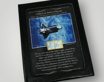 Puede incluir: Una pieza de la historia de Apolo enmarcada en negro con una foto del transbordador espacial Columbia en órbita. El texto dice: "STS-35 lanzado el 2 de diciembre de 1990, a bordo del transbordador espacial Columbia, fue la 38ª misión del transbordador. Llevaba el observatorio ASTRO-1, con cuatro telescopios enfocados en la astronomía ultravioleta y de rayos X. A pesar de los retrasos, la misión estudió con éxito los fenómenos celestes y fue la primera misión del transbordador dedicada íntegramente a la astronomía. Duró casi 9 días con una tripulación de siete miembros."