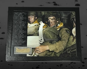 May include: A black and white photograph of three soldiers in a plane during World War II. The soldiers are wearing military uniforms and helmets. The soldiers are looking at the camera. The text "On June 6, 1944, during the D-Day Airborne Landings, thousands of paratroopers from the 82nd and 101st Airborne Divisions were dropped behind enemy lines in Normandy, close to key bridges, crossroads, and beach landing areas. The white rope attached to the Allied paratrooper parachute was a critical back-up safety measure. Designed to deploy in case the primary parachute failed. Army paratroopers in the pre-dawn darkness, faced a vital fight, engaged their reserve parachutes, fired their weapons, and saved lives. And soldiers descended into the chaotic fields and drop zones of Normandy, during Operation Overlord." is visible in the image.