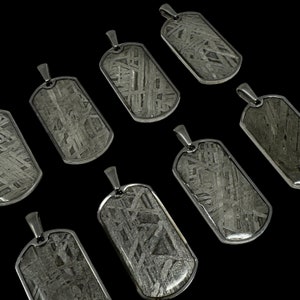 Puede incluir: Ocho colgantes de placa de identificación de perro de plata con un acabado metálico texturizado único. Cada colgante presenta un patrón diferente de líneas y remolinos.