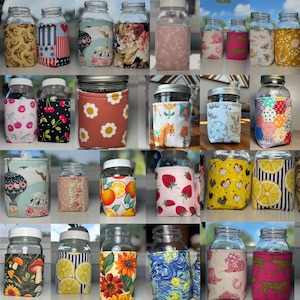 K&ouml;nnte beinhalten: Eine Sammlung von Einmachgl&auml;sern aus Glas mit verschiedenen Stoffh&uuml;llen in diversen Mustern wie Blumen, Fr&uuml;chten, Tieren, geometrischen Formen und k&uuml;nstlerischen Drucken. Jedes Glas hat einen wei&szlig;en Deckel und eine passgenaue Stoffh&uuml;lle.