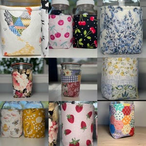 May include: A collection of glass jars featuring various fabric covers with patterns including a patchwork chicken, pink and black cherry prints, blue and white floral toile, yellow floral designs, bee motifs, and colorful geometric hexagon patches.