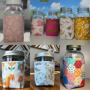 K&ouml;nnte beinhalten: Eine Sammlung von Einmachgl&auml;sern aus Glas mit verschiedenen Stoffh&uuml;llen. Die H&uuml;llen zeigen Muster wie rosa Blumen, Western-Motive, rosa Leoparden, Bienen, gelbe Blumen, stilisierte Pferde, botanische Illustrationen und bunte Sechsecke.