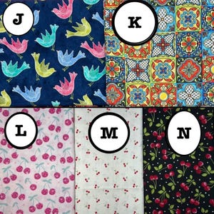 K&ouml;nnte beinhalten: Eine Sammlung von f&uuml;nf Stoffmustern mit den Bezeichnungen J, K, L, M und N. Muster J zeigt bunte V&ouml;gel auf dunkelblauem Grund. Muster K zeigt ein geometrisches Fliesenmuster. Die Muster L, M und N zeigen verschiedene Kirschmotive.