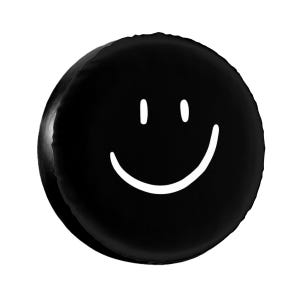 K&ouml;nnte beinhalten: Schwarzes rundes Kissen mit einem wei&szlig;en Smiley-Gesicht.